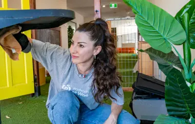 A lady from Woolworths at work is helping in a child care center