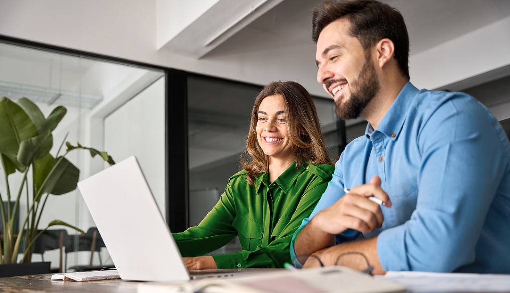 Two office workers looking at a computer screen