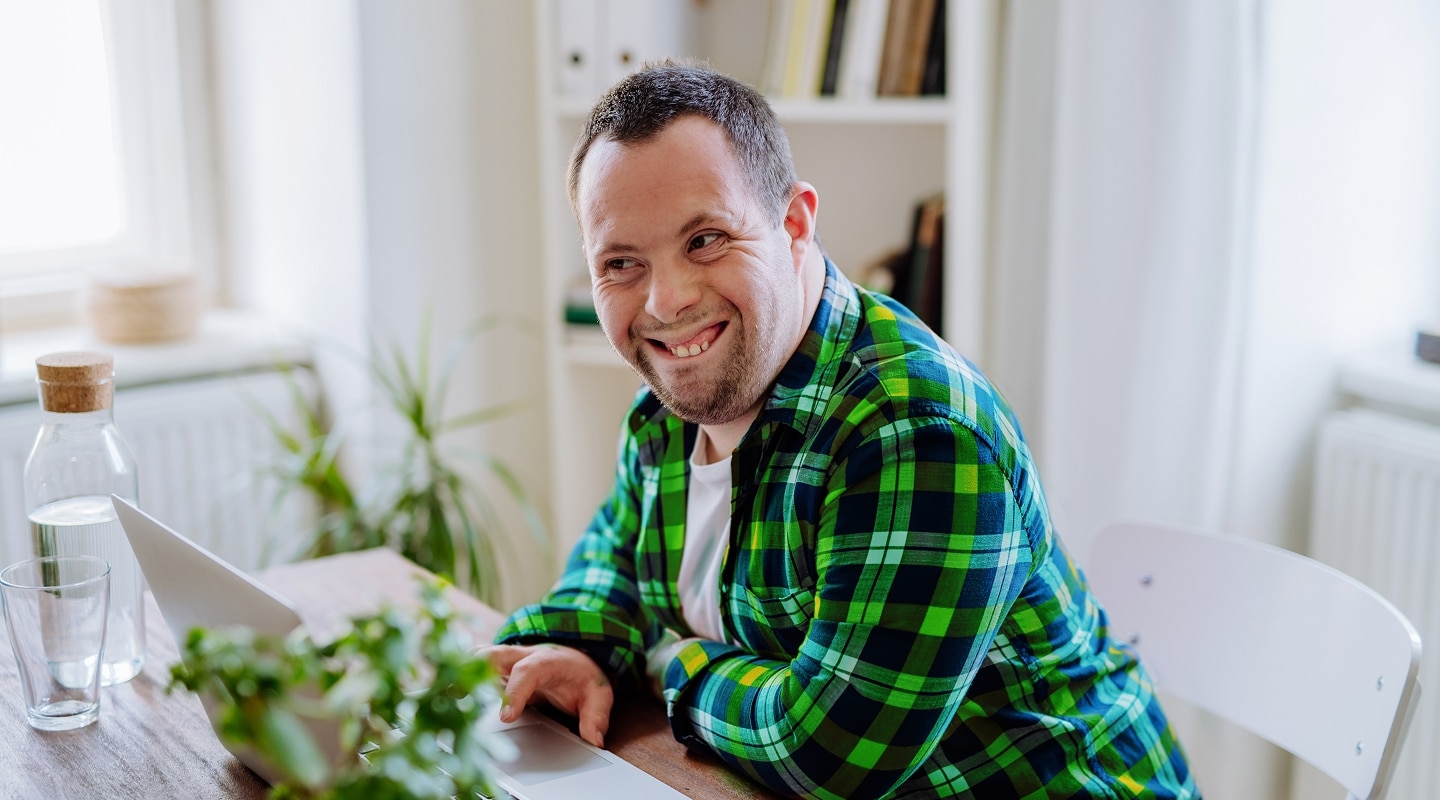 Man at laptop at dining table