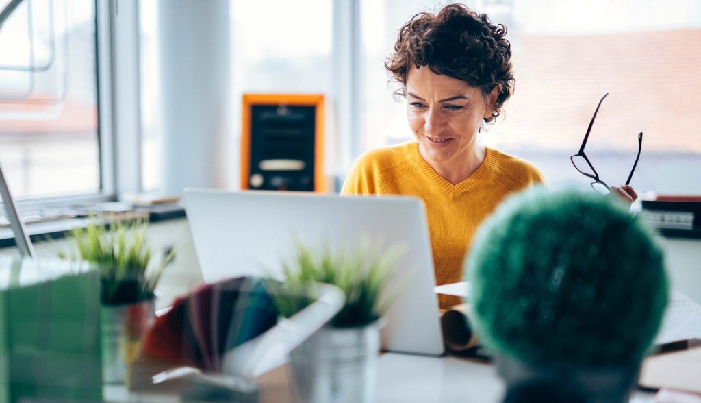 office worker sitting at desk with laptop
