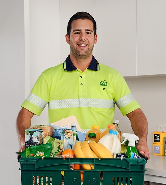 Delivery driver carrying box of fresh produce and groceries