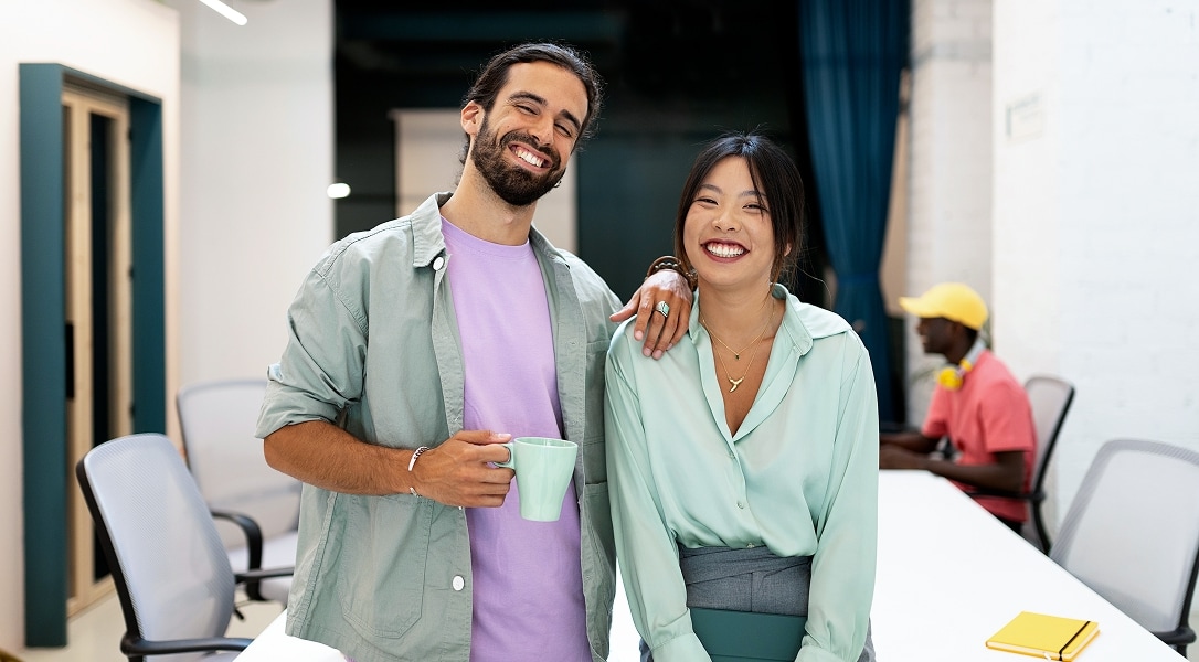 two office colleagues sitting on boardroom desk