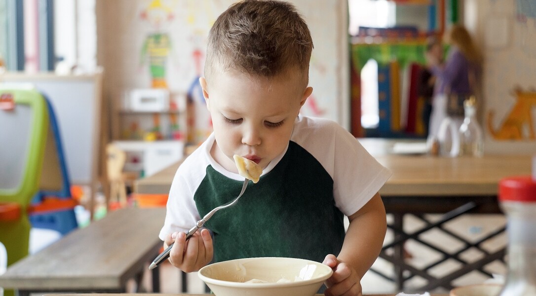 child eating pasta at daycare