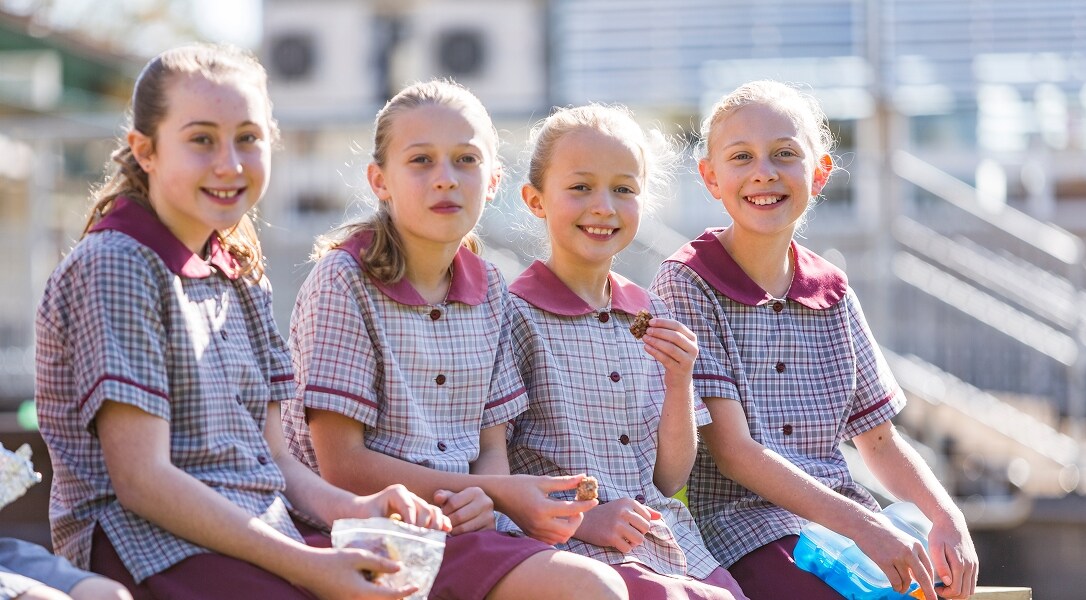 4 school kids eating lunch